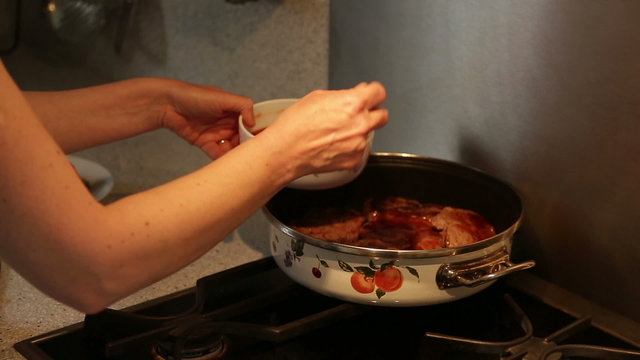 Serial videos of a housewife cooking beef in a cooker with tomatoes and green pepper