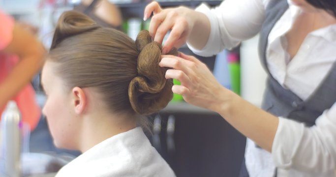 Stylist Hairdresser is Making The Hairstyle Fixing a Curles For a Woman with Long Brown Hairs Barbershop Hairdressing Salon Beauty Salon