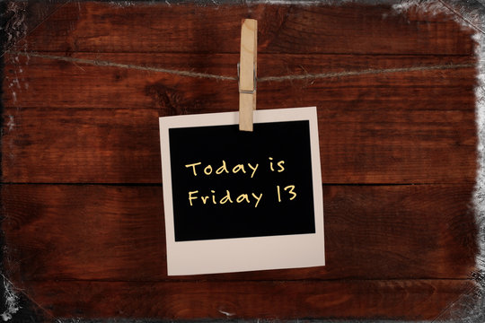 Photo paper with text Today is Friday 13 on wooden background