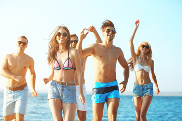 Happy friends running at the beach, outdoors