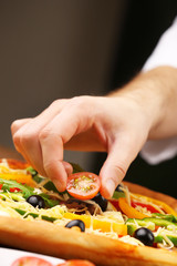 Cook making delicious pizza at the restaurant, close-up