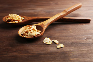 Two wooden spoons with almond flakes on the table, close-up
