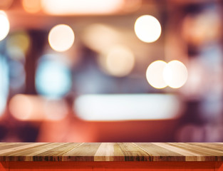 Empty brown wood table top with red trim at blur restaurant boke