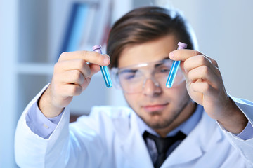 Man in laboratory checking test tubes