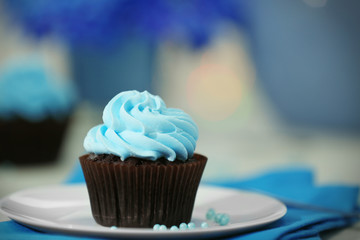 Chocolate cupcakes and flowers on a table