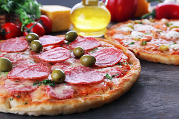 Delicious tasty pizzas with ingredients on table, closeup