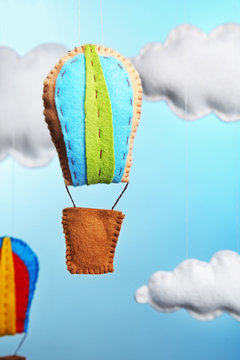 Fleece clouds and balloons on light blue background