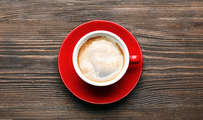 Cup of coffee on wooden table, top view