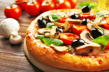 Delicious tasty pizza with ingredients on wooden table