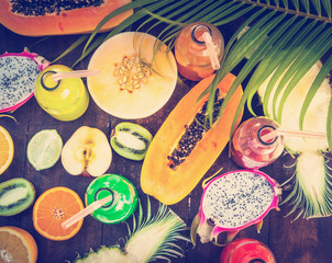 Tropical fruit on wooden background, top view