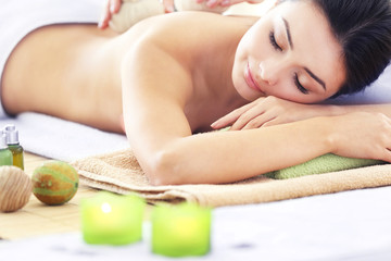 Obraz na płótnie Canvas Spa concept. Someone do relaxing massage with herbal balls to beautiful woman, close up