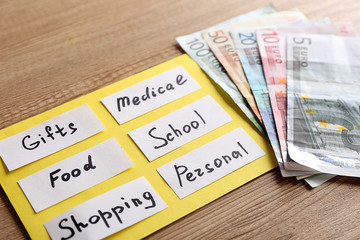 Obraz premium List of needs and cash on wooden background