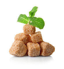 Pile of brown sugar cubes and stevia isolated on white background