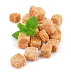 Pile of brown sugar cubes and stevia isolated on white background