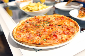 Table at home with pizza and drinks for friends