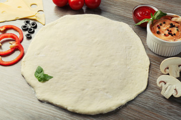Fresh ingredients for pizza preparing on wooden table