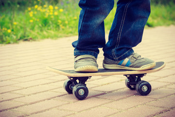 Skateboarder legs closeup. Kid skateboarding.