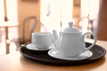 Tray with cup and teapot on table close up