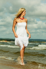 Beautiful blonde girl on beach, summertime