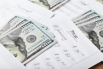 Distribution of money, financial planning, dollars in envelopes, closeup