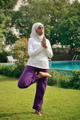 Woman doing yoga by the poolside in Dubai