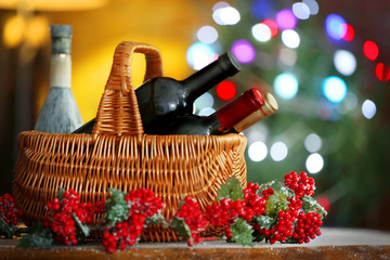 Wine in basket on blurred Christmas tree background