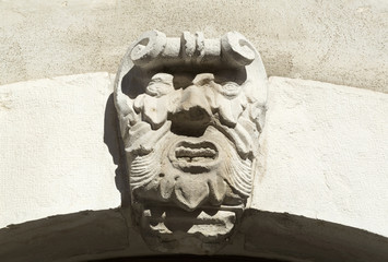 Maschera in pietra su arco