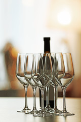 Empty wineglasses in a row and bottle on a table, close up