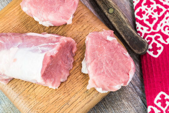 Uncooked pork tenderloin on cutting board.
