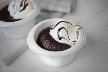 Chocolate lava cake with ice-cream in bowls, on the table