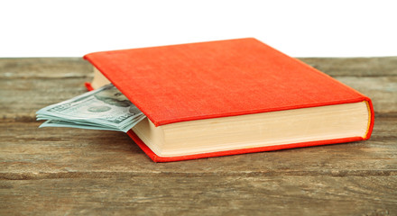 Red book with nested dollar banknotes on white background. Stash of money