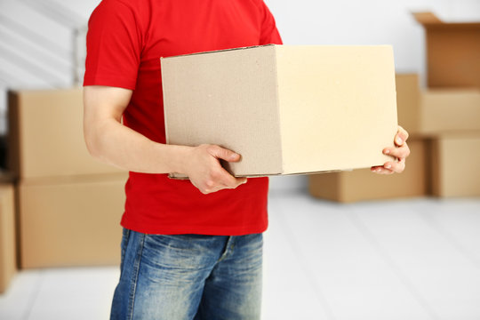 Man holding carton box in the room, close up