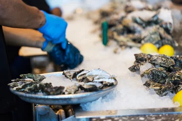 Zelfklevend Fotobehang close-up of shucking oysters © Aleksei Potov