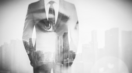 Photo of woman eye and businessman in suit. Double exposure skyscraper on the background. Black White