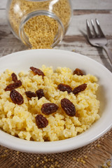 Cooked millet groats on white plate, healthy food and nutrition