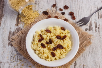 Cooked millet groats on white plate, healthy food and nutrition