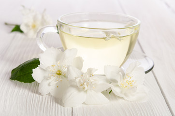 Obraz na płótnie Canvas Glass cup of tea with jasmine on the white background