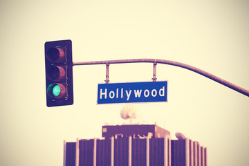 Vintage toned Hollywood street sign and traffic lights, LA, USA.