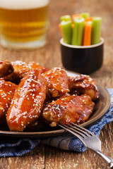 Baked chicken wings in honey sauce sprinkled with sesame seeds.