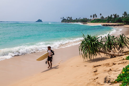Surfer on the beach in Sri-Lanka
