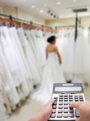 Wedding cost concept by calculator and the bride blur in background