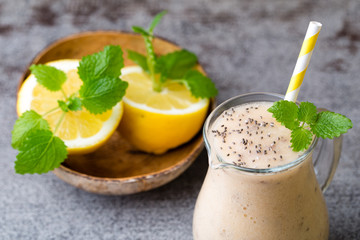 Banana and lemon smoothie, on the grey  background.