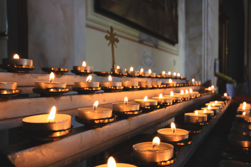 Lots of burning candles in a Catholic church.
