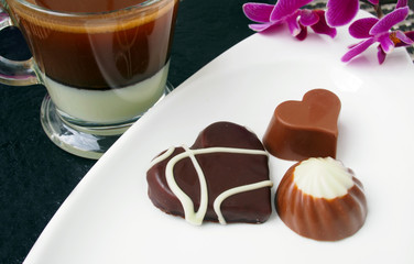 Сup of coffee espresso with milk and chocolate candies