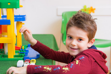 kindergartenkind spielt mit autos
