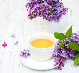 Cup of tea and lilac flowers