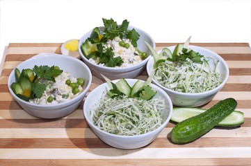 set of salads with fresh cucumbers, cabbage, green peas, peppers