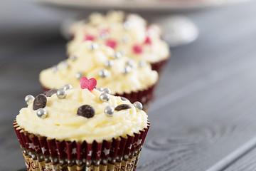 Valentines Day Red Velvet Cupcakes with Sprinkles on Dark Grey Wooden Background, Horizontal View, Close-up