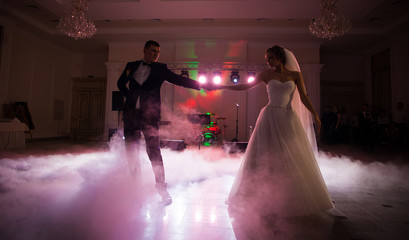 Beautiful newlywed couple first dance at reception, smoke surron