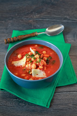 Spicy chickpea soup with spinach and parmesan cheese in a bowl